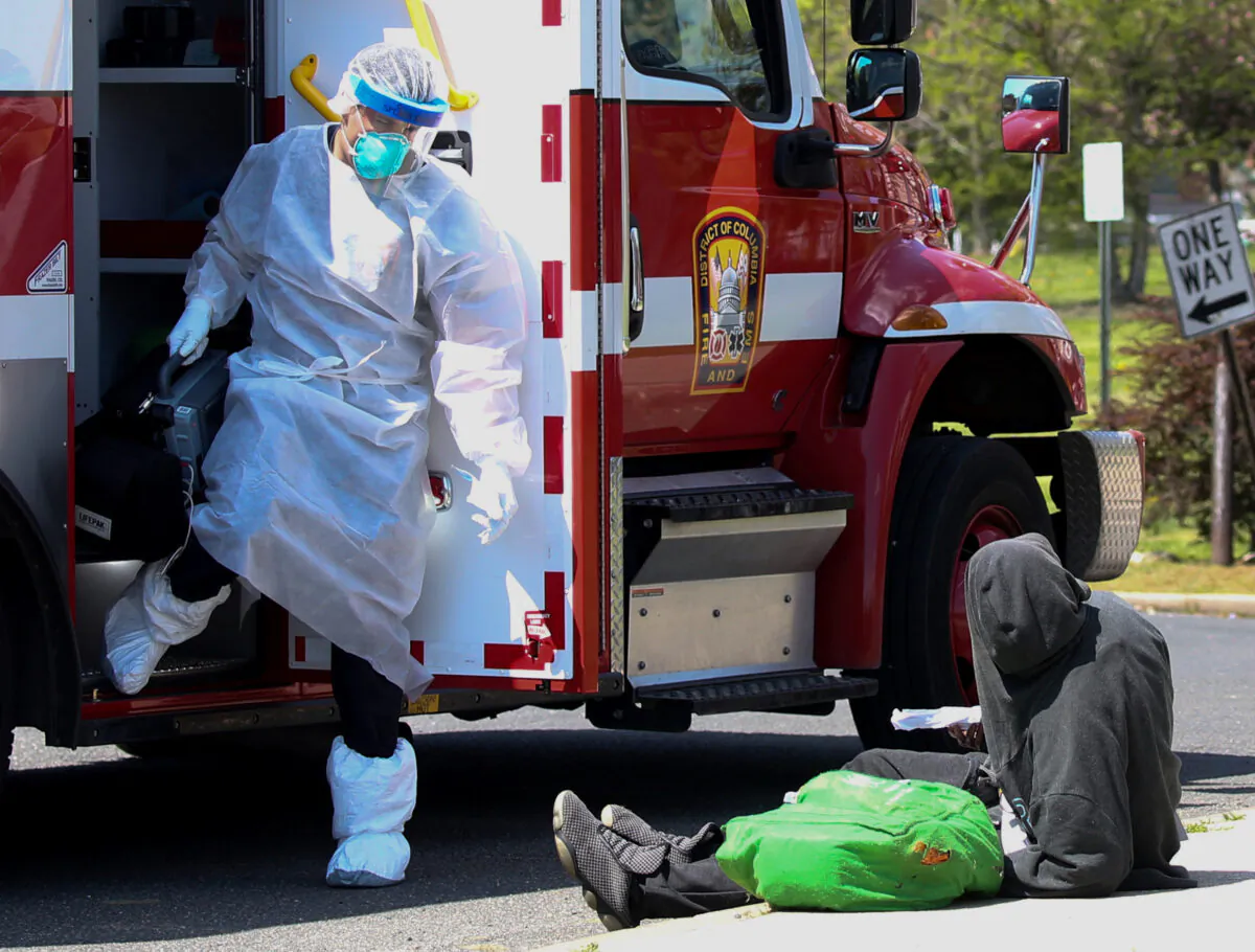A first responder wears a full covering during the CCP virus outbreak as he prepares to assist a patient in Washington, on April 8, 2020. (Jonathan Ernst/Reuters)