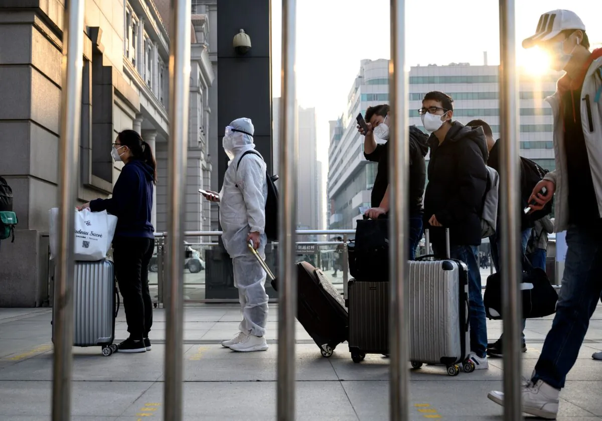 People wearing face masks arrive at Hankou Railway Station in Wuhan to take one of the first trains leaving the city in China's central Hubei Province early on April 8, 2020. (Noel Celis/AFP via Getty Images)