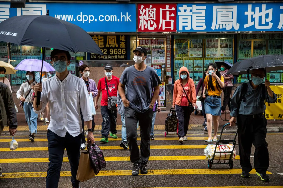 ImpactHK founder and CEO Jeff Rotmeyer (C) crosses a street after handing out supplies of face masks, hand sanitisers, food and drinks to the homeless and people in need in Hong Kong on March 28, 2020. (Isaac Lawrence/AFP via Getty Images)