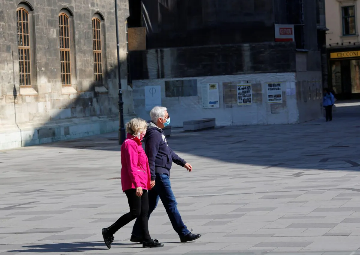 People wearing masks walk down a pedestrian zone in Vienna on April 6, 2020. (Leonhard Foeger/Reuters)