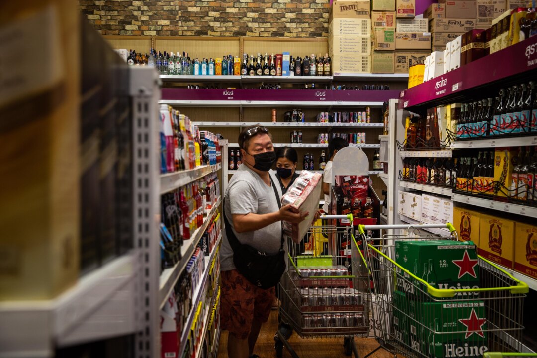 People wearing face masks purchase cases of beer at a grocery store in Bangkok, Thailand on April 9, 2020. (Lauren DeCicca/Getty Images)