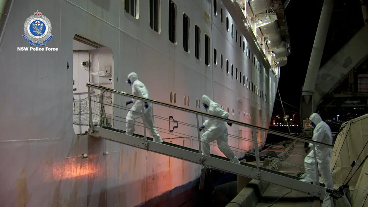 NSW Police personnel in personal protective equipment board the Ruby Princess during the Strike Force Bast raid of the cruise ship at Port Kembla, New South Wales, Australia on, April 8, 2020, in this still image from video. (NSW Police via Reuters)