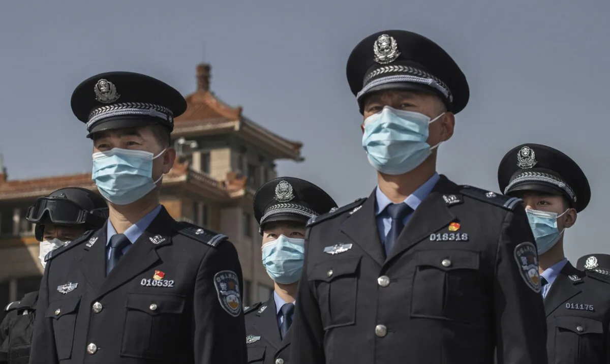 Chinese police officers wear protective masks as they observe three minutes of silence to mark the country's national day of mourning for COVID-19 at Beijing Railway Station in Beijing, China, on April 4, 2020. (Kevin Frayer/Getty Images)