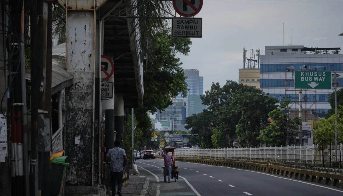 A stretches vendor pushes his cart along a road which would ordinarily be bumper to bumper traffic in Jakarta, Indonesia, on April 8, 2020. (Ed Wray/Getty Images)