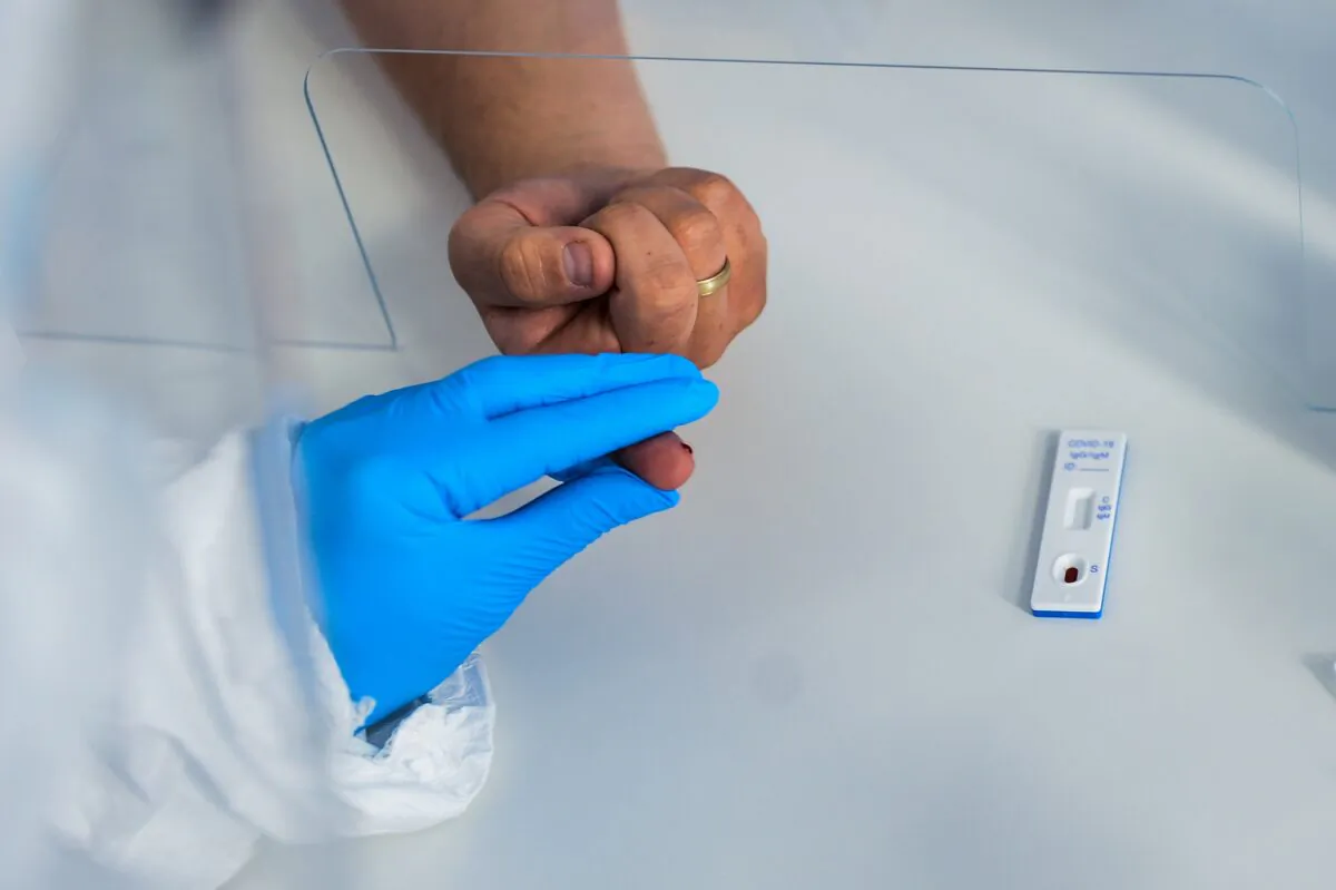 A health worker wears a protective mask and suit as she extracts blood from a patient to perform an antibody test for COVID-19 at the Dworska Hospital in Krakow, Poland on April 9, 2020. (Omar Marques/Getty Images)