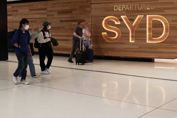 Travellers walk towards the departures gate