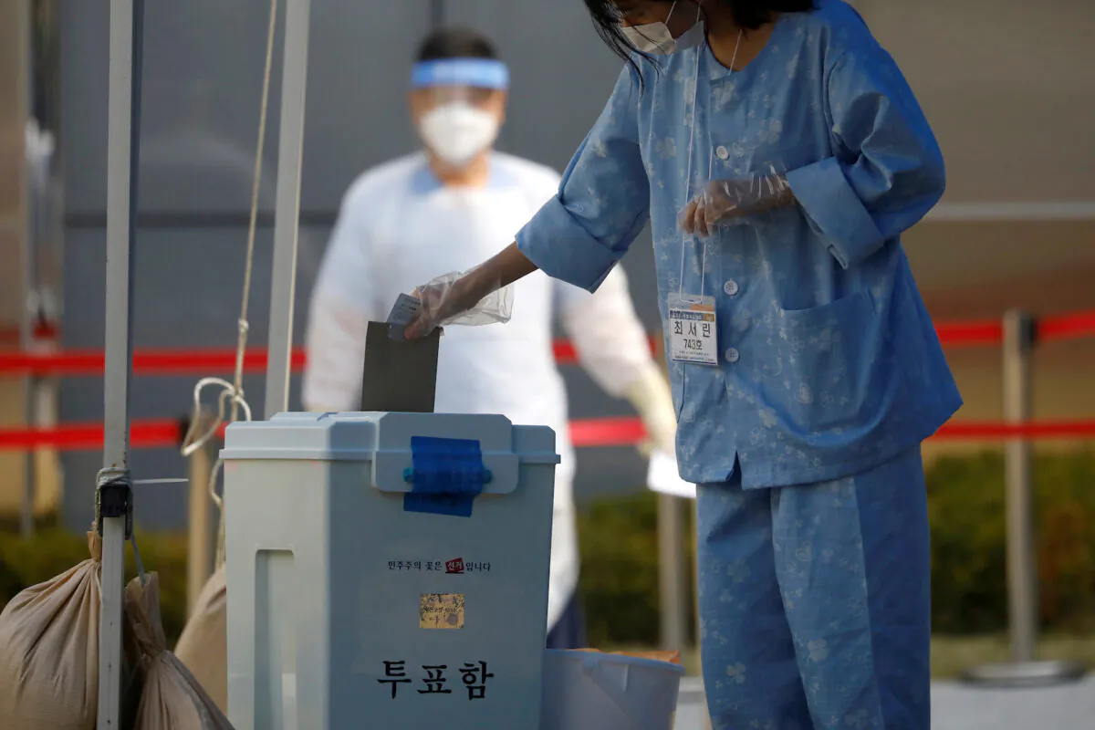 A South Korean patient affected with the CCP virus disease (COVID-19) casts her ballot for the parliamentary election at a polling station set up at a quarantine center in Yongin, South Korea, on April 11, 2020. (Kim Hong-Ji/File Photo via Reuters)