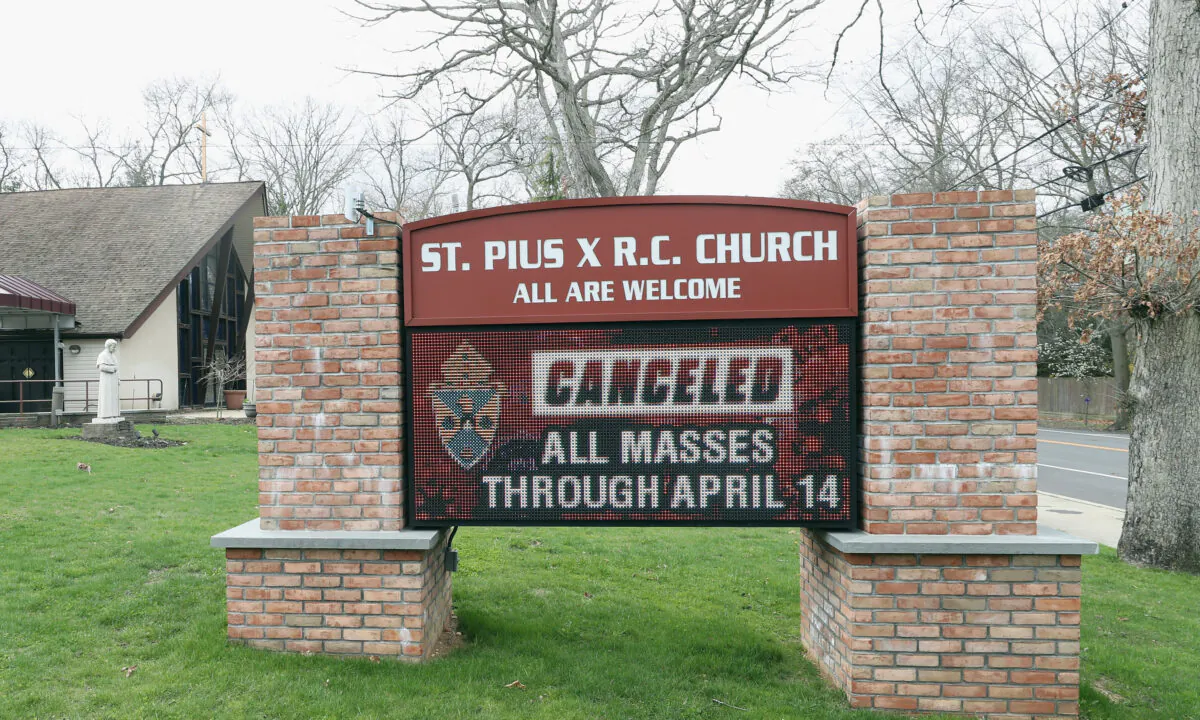 A display in front of St. Pius X R.C. Church on April 10, 2020, displays a message that all masses through April 14 are cancelled in Plainview, New York. (Bruce Bennett/Getty Images)