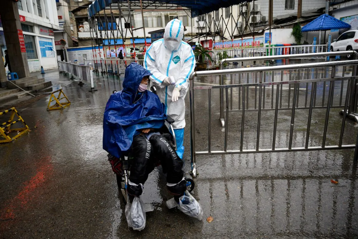 A medical worker assists a man seeking treatment at a fever clinic at Huanggang Zhongxin Hospital in Huanggang, in China's central Hubei province on March 27, 2020. (Noel Celis/AFP via Getty Images)