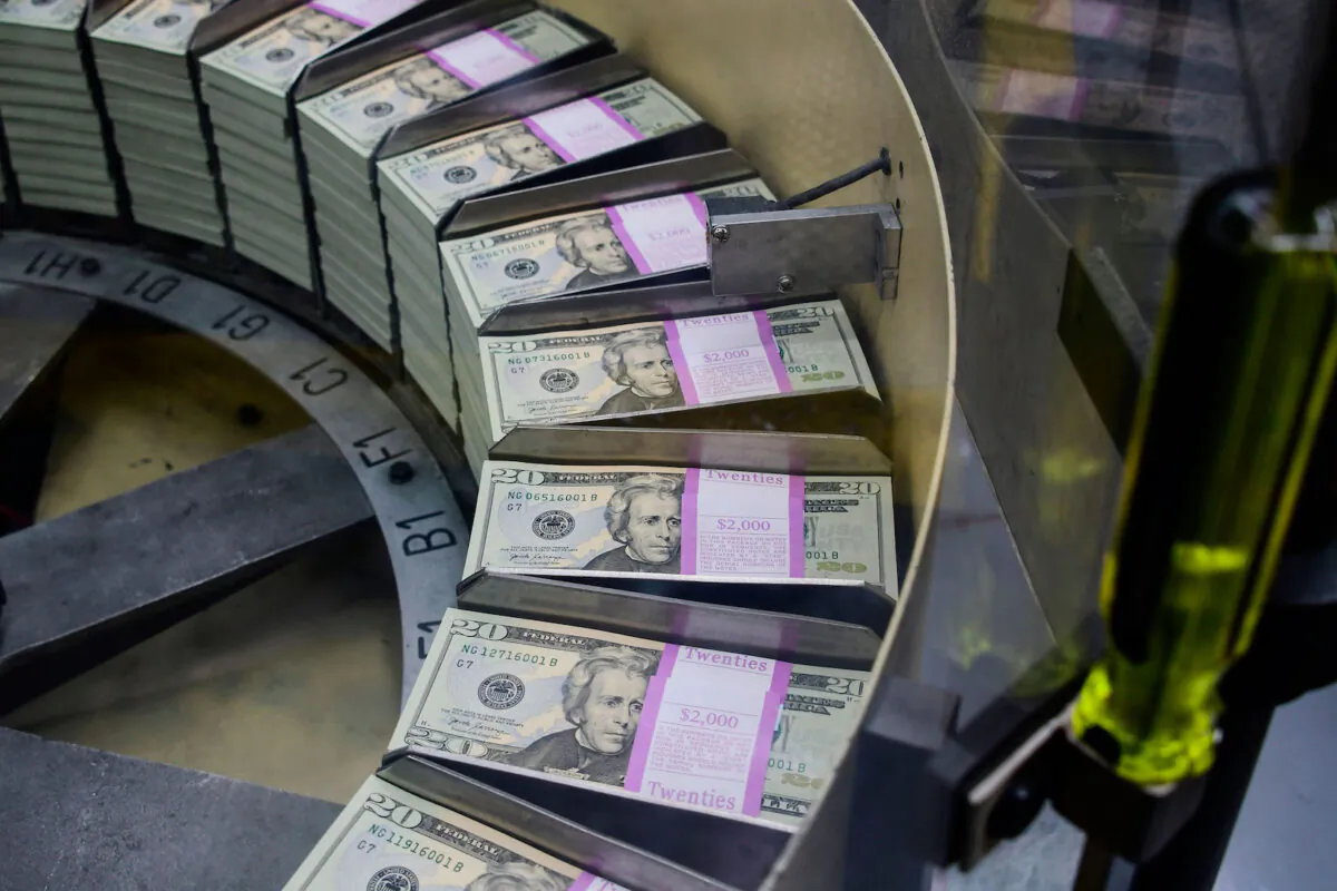 Packs of freshly printed 20 USD notes are processed for bundling and packaging at the US Treasury's Bureau of Engraving and Printing in DC on July 20, 2018. (Eva Hambach/AFP via Getty Images)