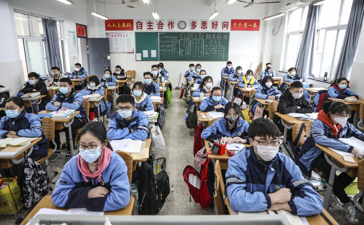 Students sit in a classroom as grade three students in middle school and high school return after the term opening was delayed due to the CCP virus outbreak in Huaian, Jiangsu province, China on March 30, 2020. (STR/AFP via Getty Images)