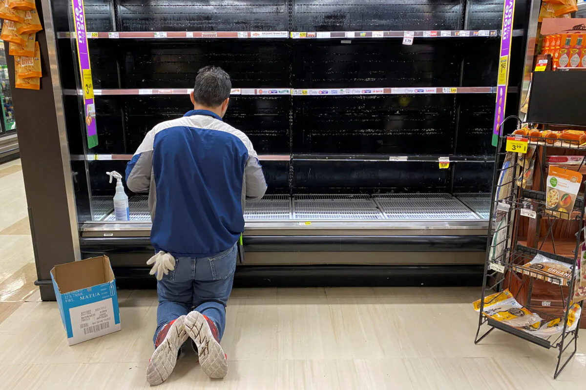 A store worker cleans an empty display for eggs inside Kroger Co.'s Ralphs supermarket amid fears of the global growth of CCP virus cases, in Los Angeles, California, on March 15, 2020.  (Patrick T. Fallon/Reuters, File Photo)