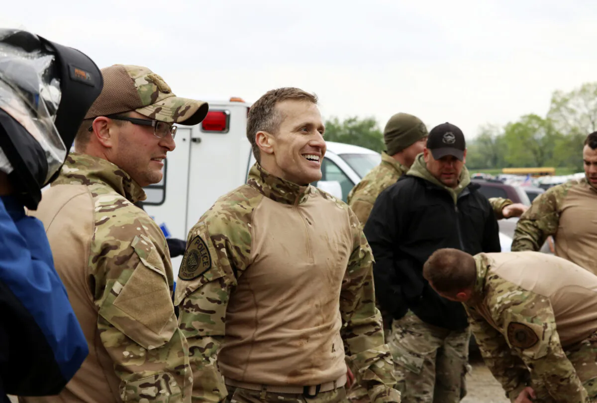 Missouri Gov. Eric Greitens (C) along with his teammates from the St. Louis County Police Department, catch their breath after completing the obstacle course at the SEMO SWAT Challenge in Fredericktown, Mo., on April 22, 2017. (Jacob Scott/Daily Journal via AP)