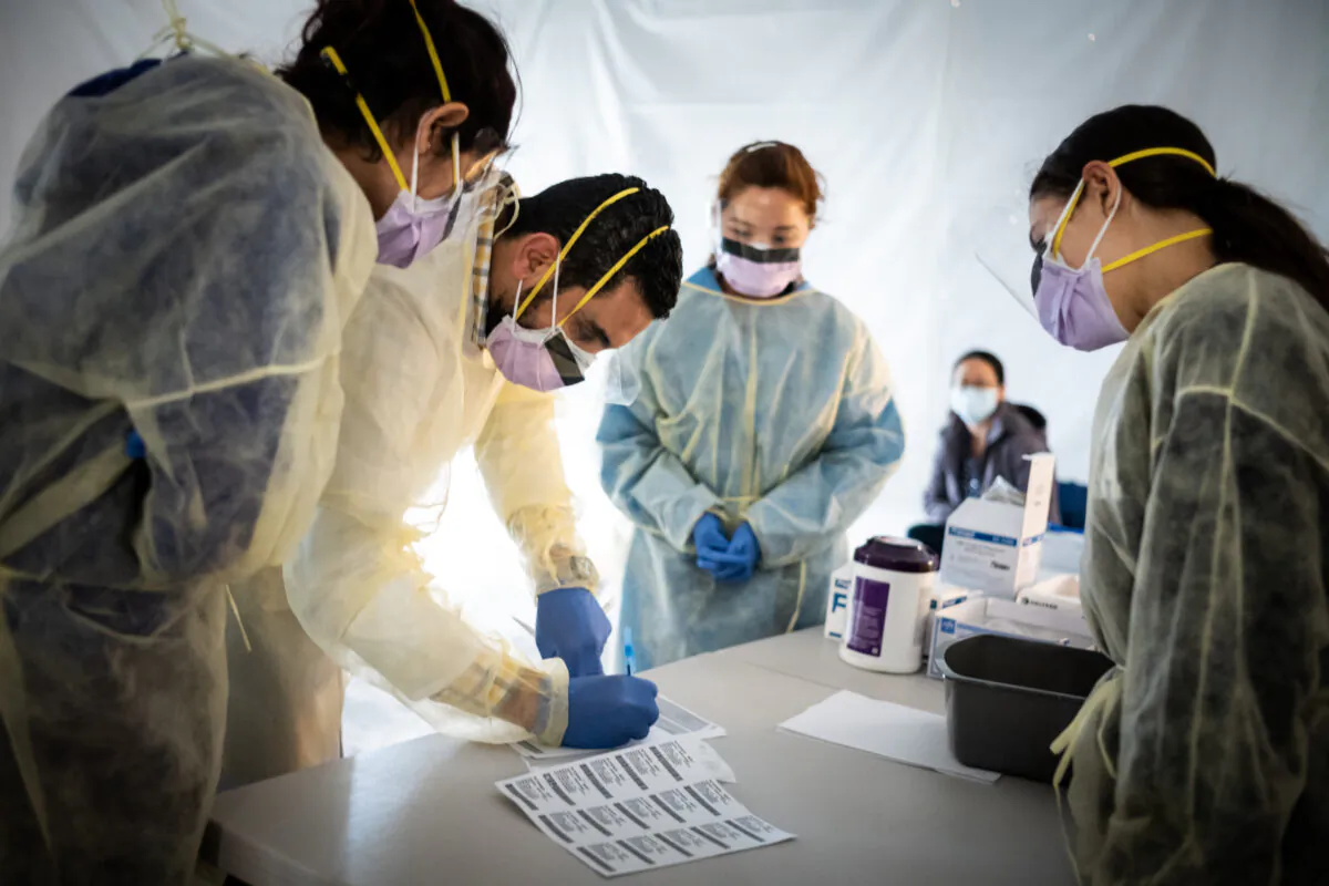 Doctors test hospital staff with flu-like symptoms for COVID-19 in set-up tents to triage possible COVID-19 patients outside before they enter the main emergency department area at St. Barnabas hospital in the Bronx, New York City, on March 24, 2020. (Misha Friedman/Getty Images)