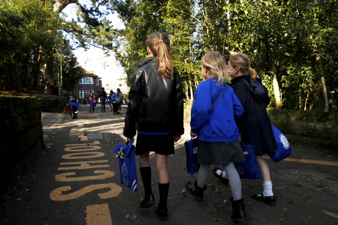 Children walk home from Altrincham C.E. aided primary school after the government's policy to close all schools from today due to the coronavirus pandemic in Altrincham, UK, on March 20, 2020. (Clive Brunskill/Getty Images)