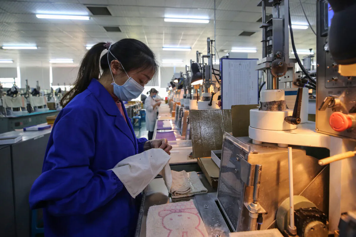 An employee is working at a photoelectric production line at a factory in Wuhan, China on April 6, 2020. (STR/AFP via Getty Images)