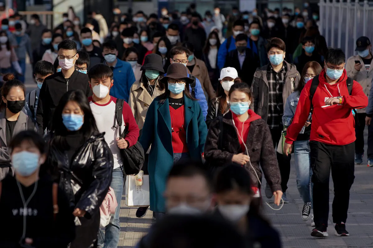 Commuters wear protective masks as they exit a subway station during Monday rush hour in Beijing,on April 13, 2020. (Lintao Zhang/Getty Images)