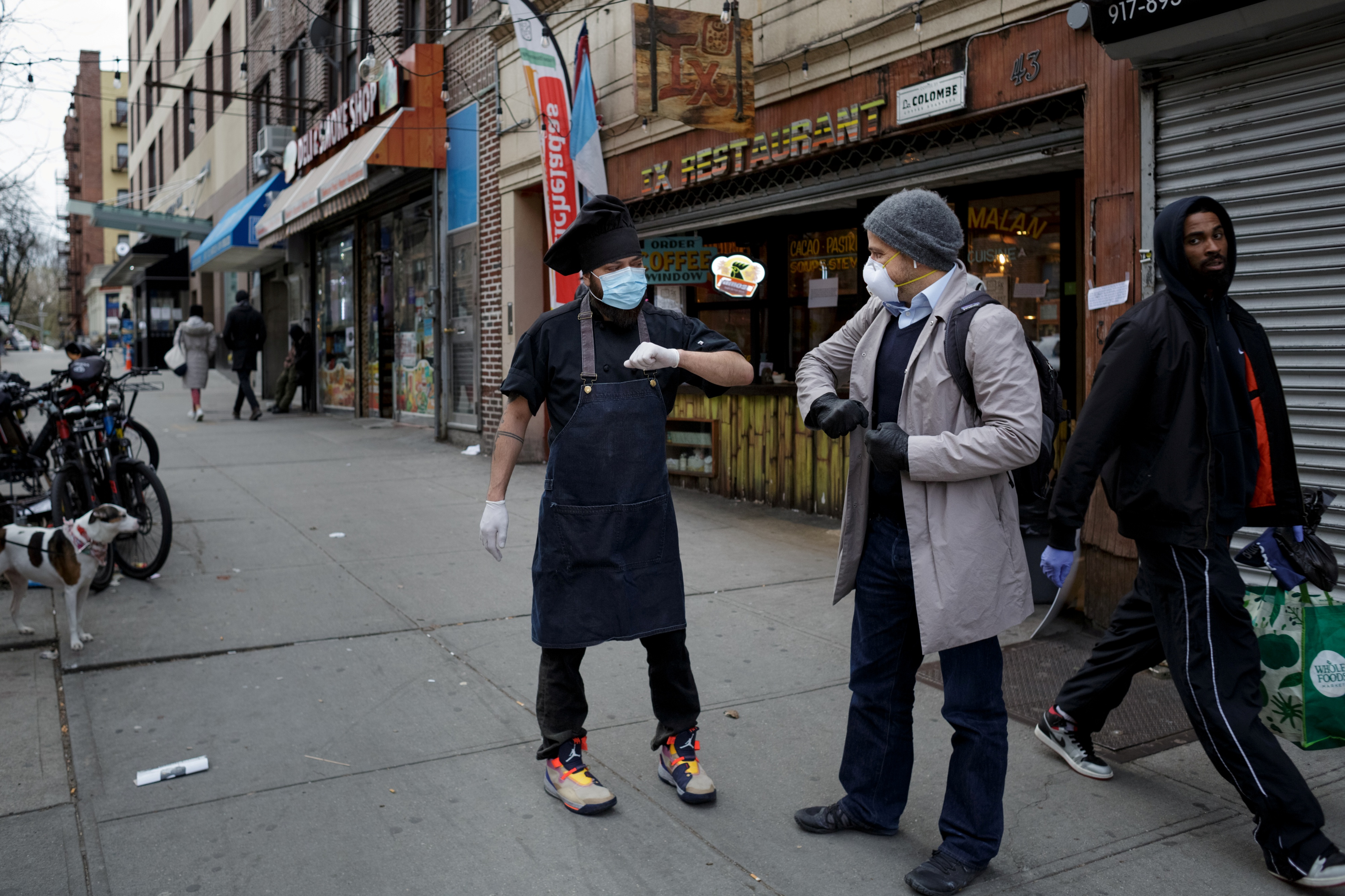 Chef Jorge Cardenas shares an elbow bump with regular Ix customer Lorenzo Bernasconi outside of Ix restaurant in the Brooklyn borough of New York City, U.S., on April 2, 2020 amid the CCP virus outbreak. (Anna Watts/Reuters)