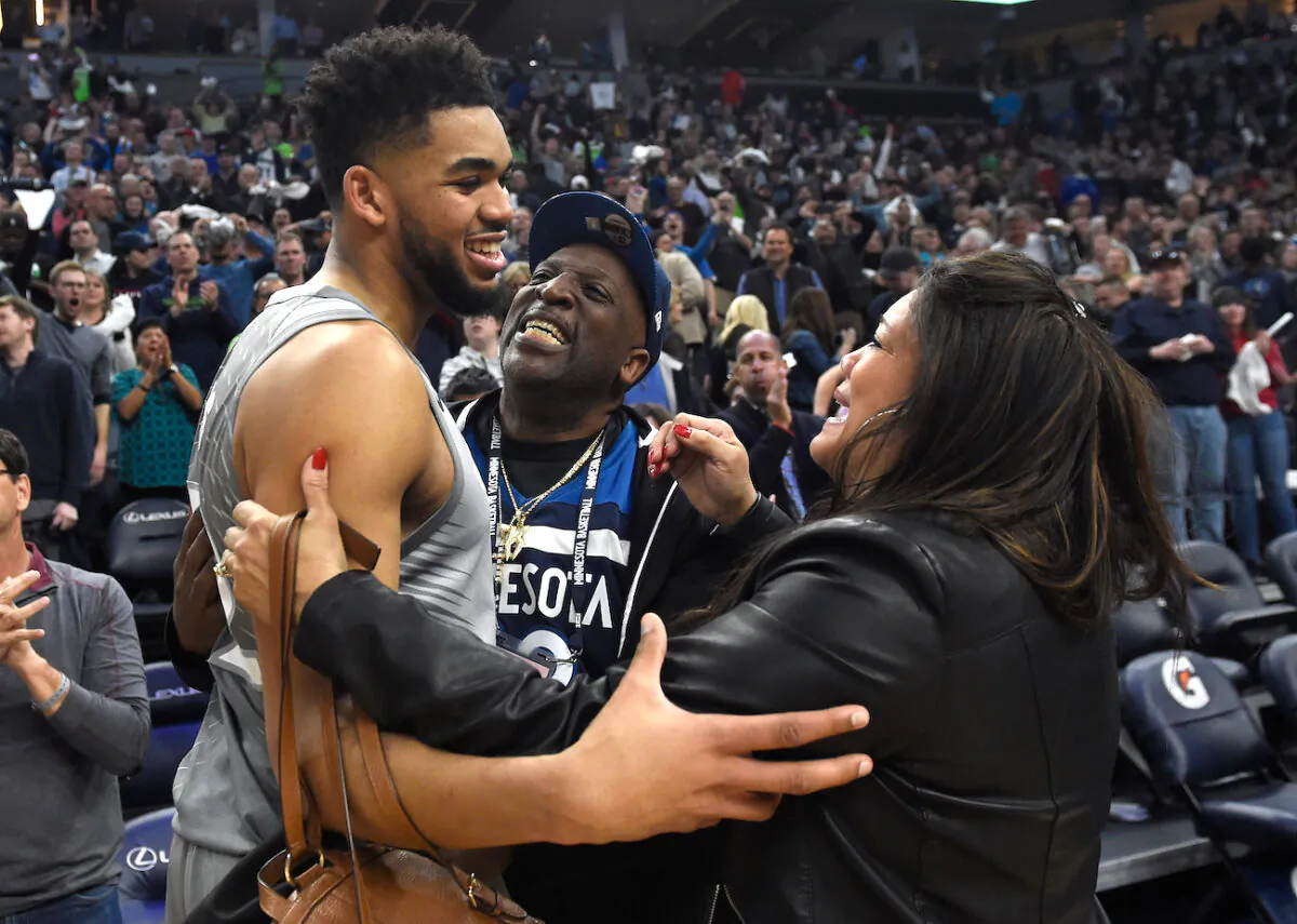 Karl-Anthony Towns of the Minnesota Timberwolves hugs his parents, Karl and Jacqueline Towns, after winning the game against the Denver Nuggets at the Target Center in Minneapolis, Minnesota, on April 11, 2018. (Hannah Foslien/Getty Images)