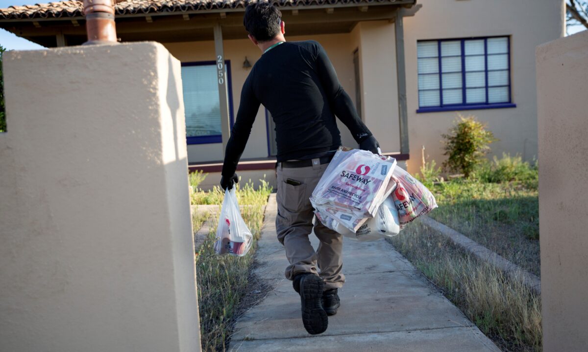 Instacart employee Eric Cohn, 34, delivers groceries to a residence while wearing a respirator mask.