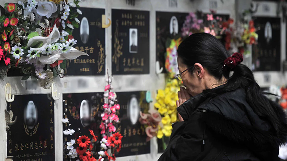 A Chinese woman praying at the grave of a loved one at the Babaoshan cemetery in Beijing to mark the annual Qing Ming (Ching Ming) Festival or grave-sweeping day. Visiting the graves of ancestors during Qing Ming. (Photo credit should read STR/AFP via Getty Images)