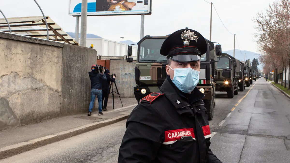 A Carabinieri officer blocks the road traffic as a convoy of military vehicles arrives at the Monumental Cemetery in Bergamo near Milan, Italy, on March 26, 2020. (Emanuele Cremaschi/Getty Images)