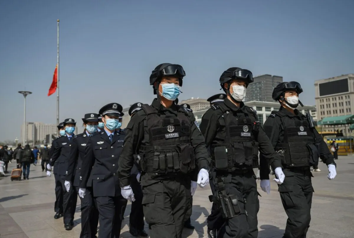 Chinese police officers march in formation at Beijing Railway Station on April 4, 2020 in Beijing, China. (Photo by Kevin Frayer/Getty Images)