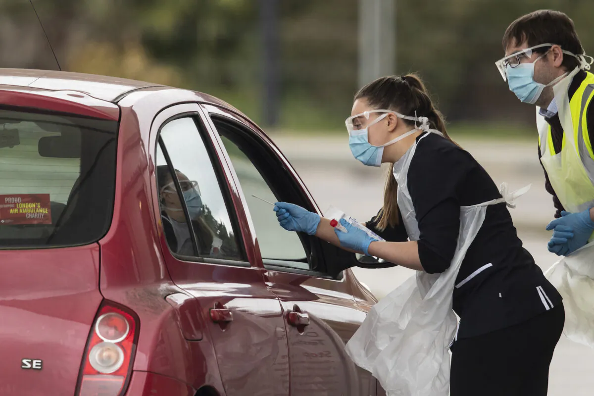 A nurse takes a swab at a COVID-19 drive-through testing station for NHS staff  in Chessington, United Kingdom, on March 30, 2020. (Dan Kitwood/Getty Images)