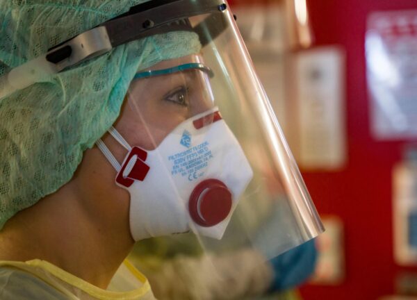 Nurse Lena Mueller wears a face mask and protective clothing