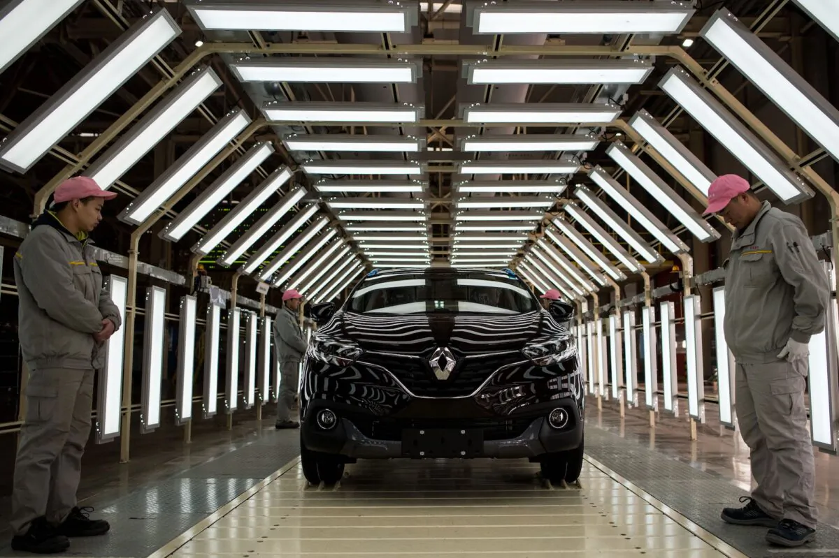 Chinese workers stand next to a Kadjar car at the production line of France's Renault and China's Dongfeng Group factory in Wuhan, China, on Feb. 1, 2016. (Johannes Eisele/AFP/Getty Images)
