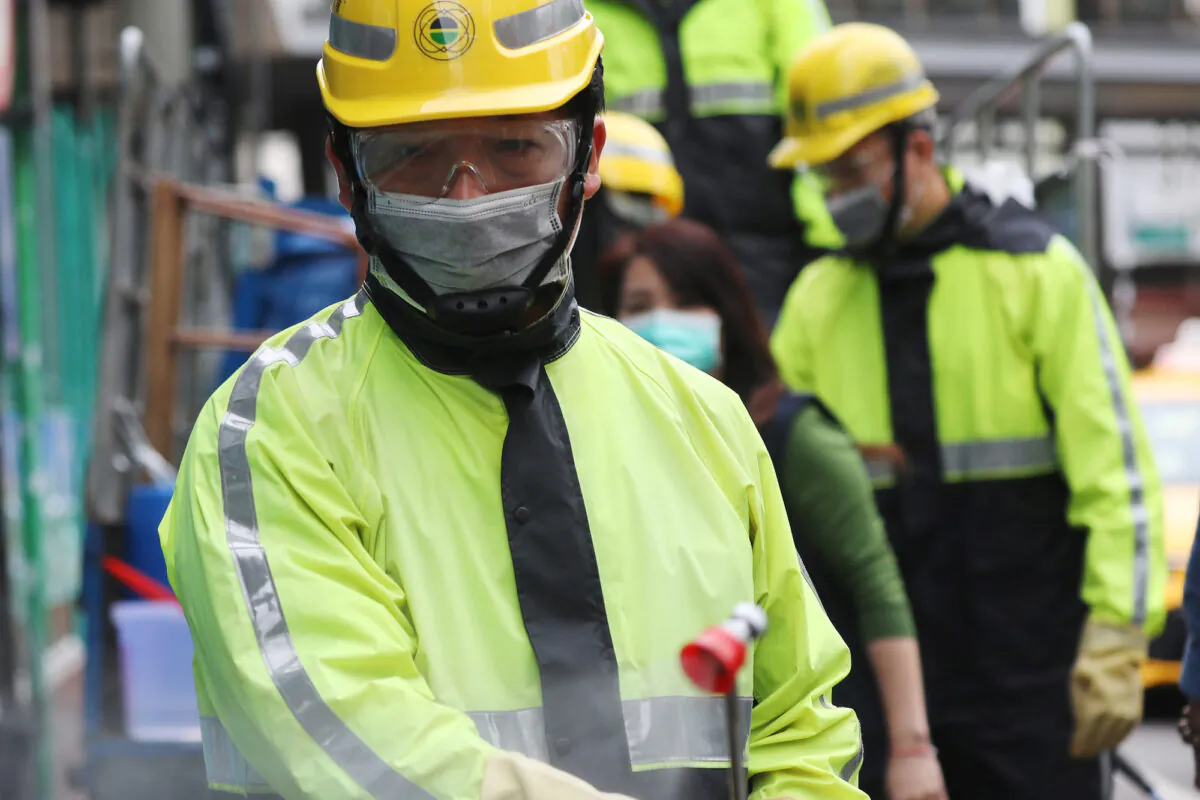 Government staffers spray disinfectant outside a train station in Taoyuan city, Taiwan, on April 1, 2020. (Ann Wang/Reuters)