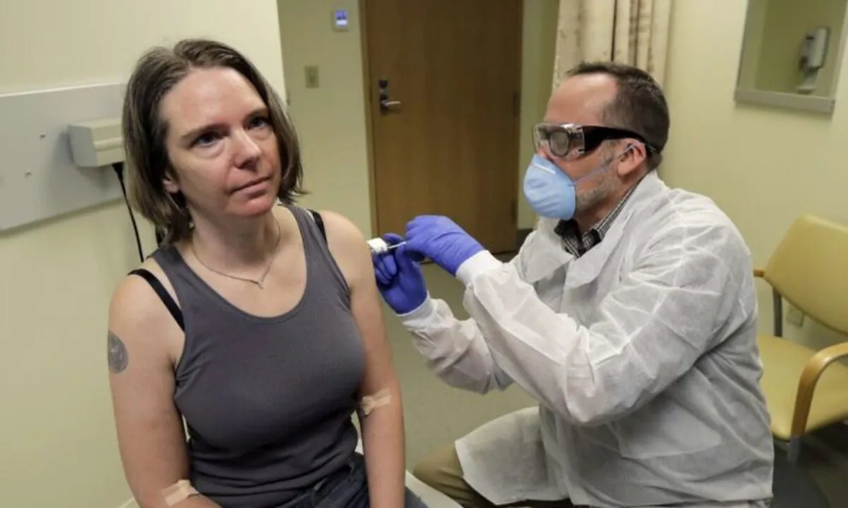 A pharmacist gives Jennifer Halle (L), the first shot in the first-stage safety study clinical trial of a potential vaccine for COVID-19, the disease caused by the new coronavirus, at the Kaiser Permanente Washington Health Research Institute in Seattle on March 16, 2020. (Ted S. Warren/AP Photo)