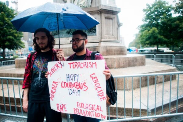 two men protest columbus statue