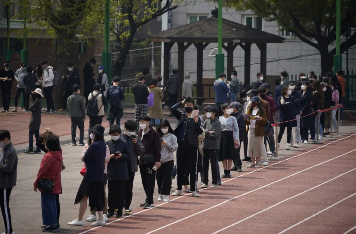 Voters wearing face masks in an effort to prevent the spread of COVID-19 wait in line to cast their ballots at a polling station during the parliamentary election in Seoul, South Korea, on April 15, 2020. (Kim Hong-Ji/Reuters)