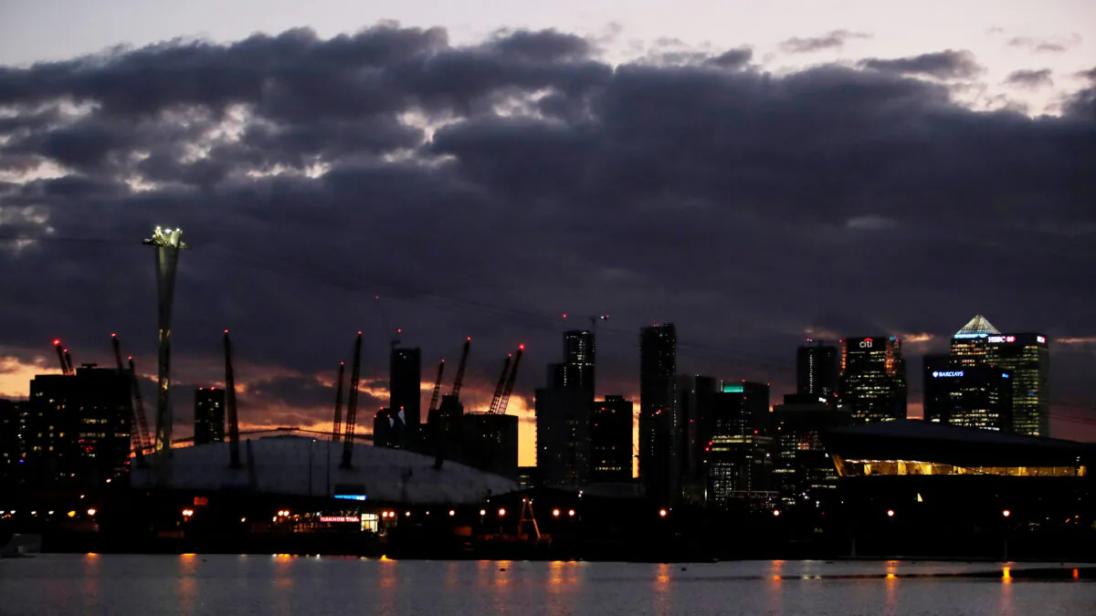 Canary Wharf is seen with the O2 arena, illuminated blue in support of NHS and other key workers as the number of coronavirus cases increases globally, London, Britain, April 2, 2020. (Paul Childs/Reuters)