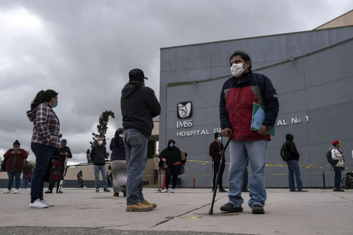 People wearing face masks as a preventive measure against the spread of COVID-19, line up to access the IMSS General Hospital Regional 1 in Tijuana, Baja California State, Mexico, on April 13, 2020 during the novel coronavirus pandemic. (Guillermo Arias/AFP via Getty Images)