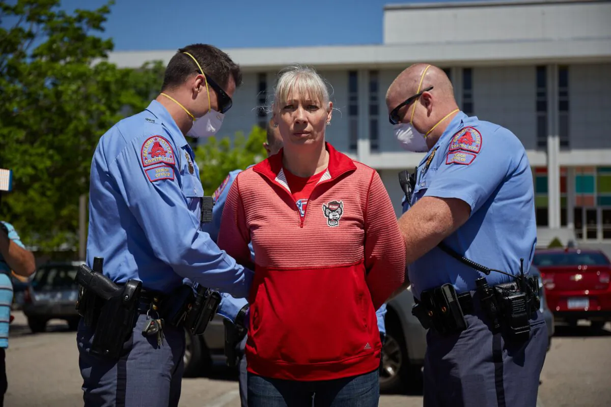 A protester from a grassroots organization called ReopenNC is arrested after refusing to leave a parking lot during a demonstration against the North Carolina CCP virus lockdown at the North Carolina State Legislature in Raleigh, North Carolina, on April 14, 2020. (Logan Cyrus/AFP via Getty Images)