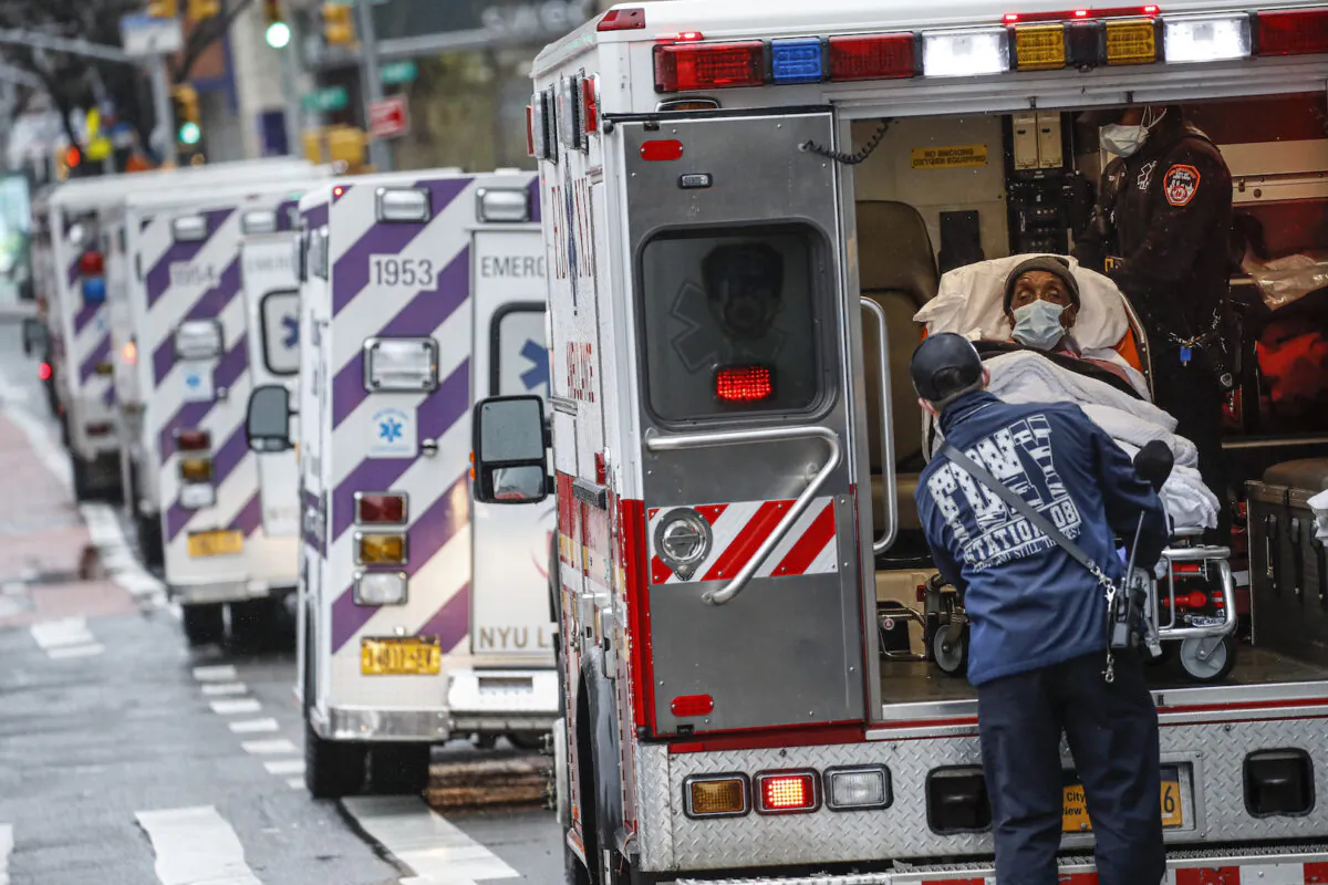 A patient arrives in an ambulance cared for by medical workers wearing personal protective equipment due to COVID-19 concerns outside NYU Langone Medical Center in New York on Apr. 13, 2020. (John Minchillo/AP)