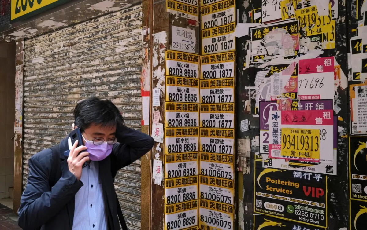 A man wearing protective mask walks past a closed shop covered with advertisements for rental space at Mongkok, following the outbreak of the COVID-19, in Hong Kong, China, on March 13, 2020. (Tyrone Siu/Reuters)