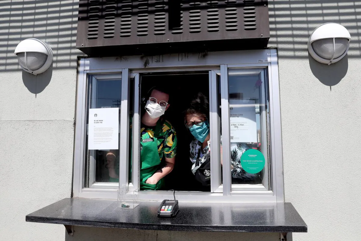 Starbucks employees wear a mask while working the drive-thru window in Edgewater, Colorado, on April 7, 2020. (Matthew Stockman/Getty Images)