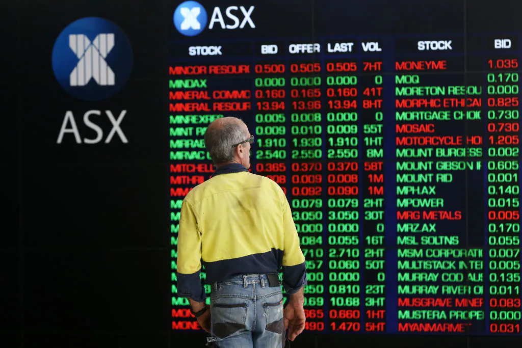 A man looks at an electronic board displaying stock information at the Australian Securities Exchange, operated by ASX Ltd. in Sydney, Australia, on March 16, 2020. (Brendon Thorne/Getty Images)