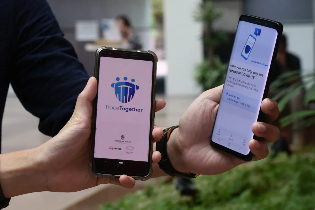 Government Technology Agency (GovTech) staff demonstrate Singapore's new contact-tracing smarthphone app called TraceTogether, as a preventive measure against the COVID-19 coronavirus in Singapore on March 20, 2020. (Catherine Lai/AFP via Getty Images)