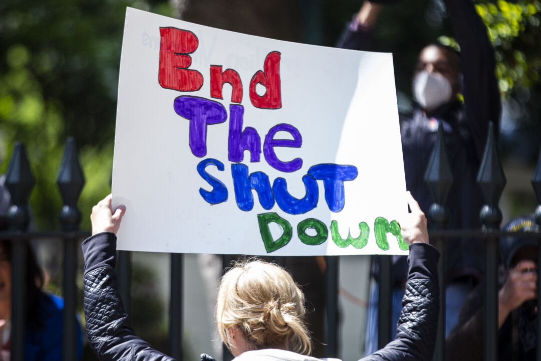 A demonstrator holds a sign at the Virginia State Capitol, in Richmond, Va, on April 16, 2020. (Zach Gibson/Getty Images)