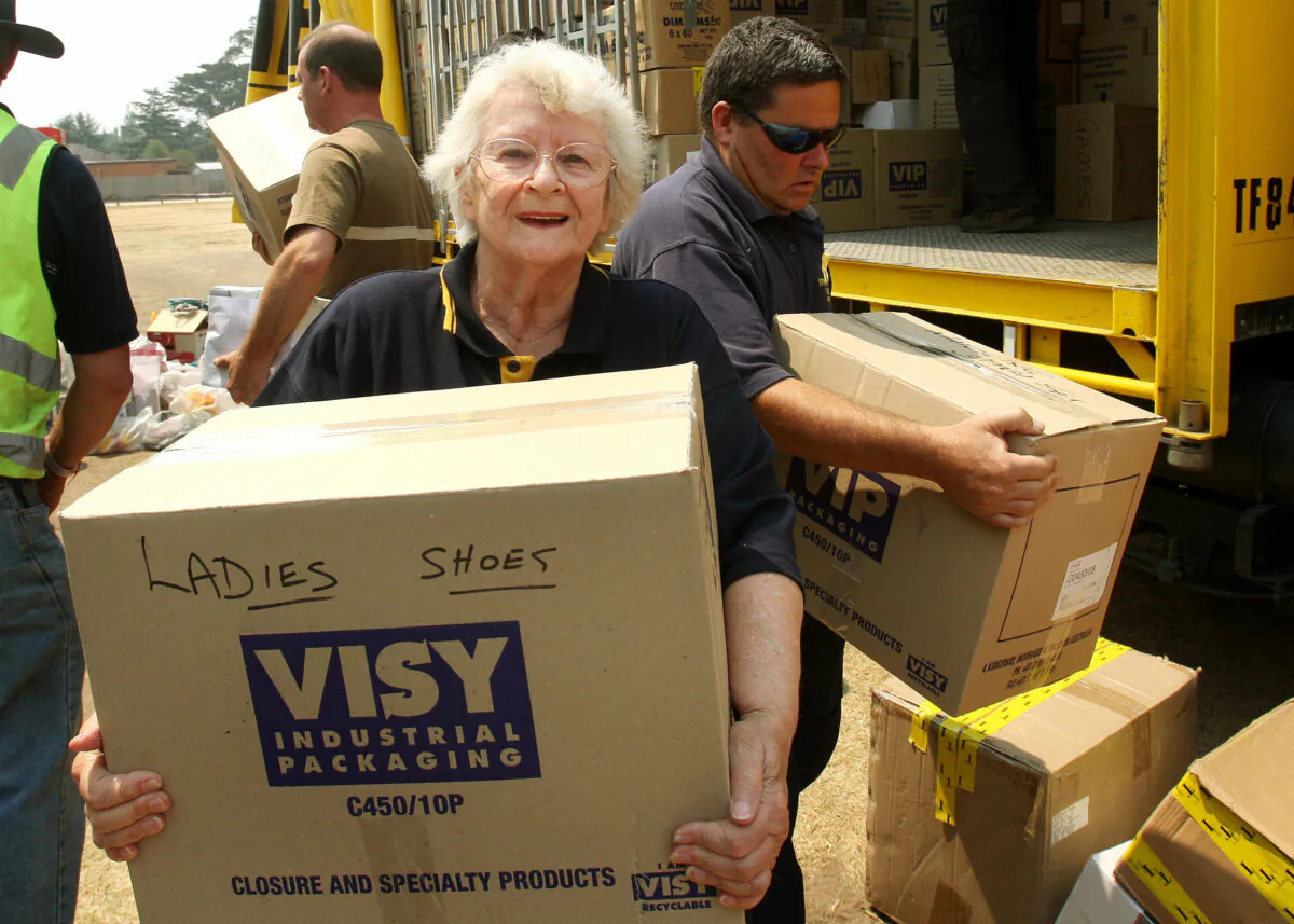 TO GO WITH Australia- An elderly volunteer helps to unload a truck of donated goods, north of Melbourne on February 13, 2009. ( WILLIAM WEST/Getty Images)