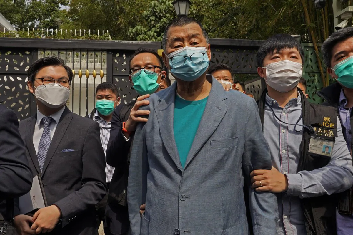 Hong Kong media tycoon Jimmy Lai, center, who founded local newspaper Apple Daily, is arrested by police officers at his home in Hong Kong on April 18, 2020. (Vincent Yu/AP Photo)