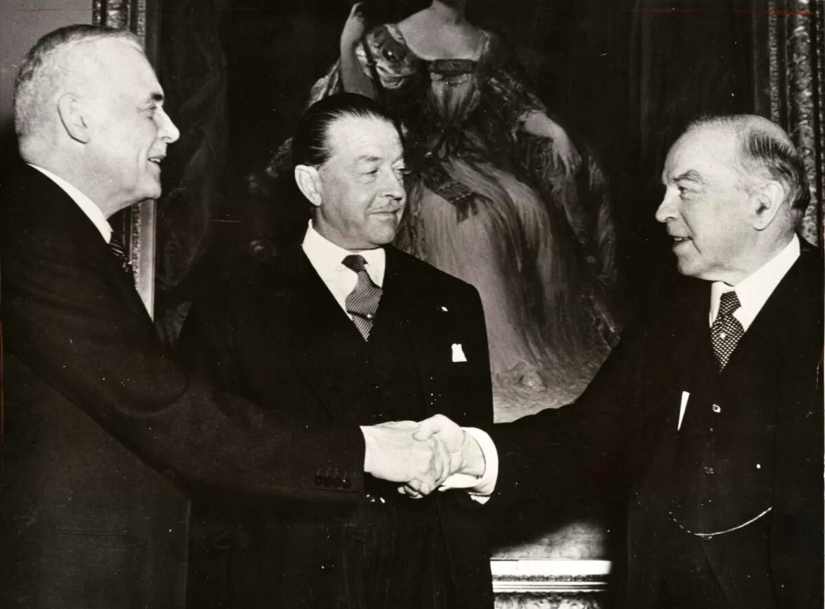 Prime Minister William Lyon Mackenzie King (R) shakes hands with External Affairs Minister Louis St. Laurent as he hands over the Liberal leadership, and thus the prime minister's office, to St. Laurent on Nov. 15, 1948. In the centre is Governor General Harold Alexander. (The Canadian Press)