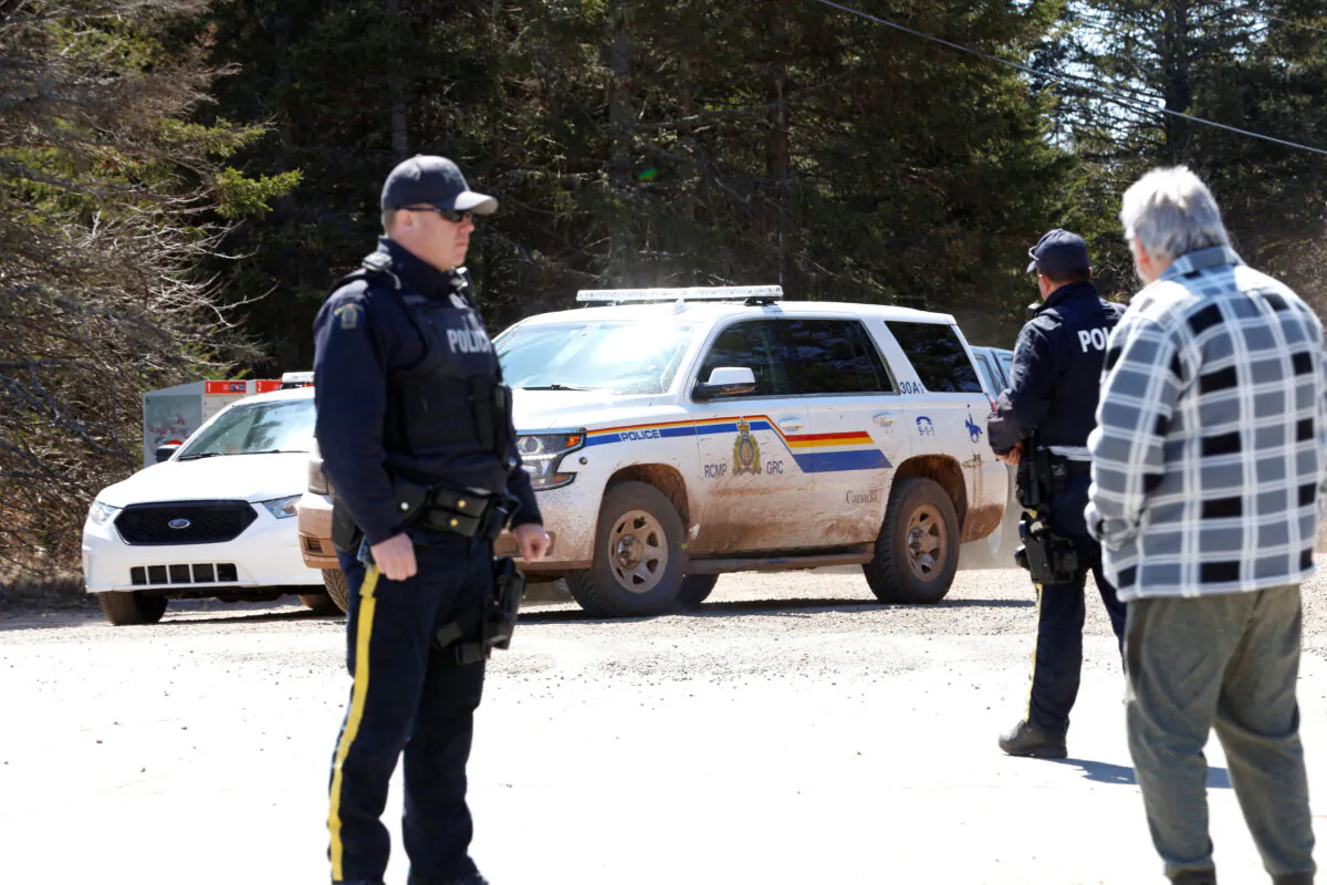 A Royal Canadian Mounted Police (RCMP) SUV pulls up to the end of Portapique Beach Road while an officer speaks with a man after the police finished their search for shooter Gabriel Wortman, in Portapique, Nova Scotia, Canada on April 19, 2020. (John Morris/Reuters)