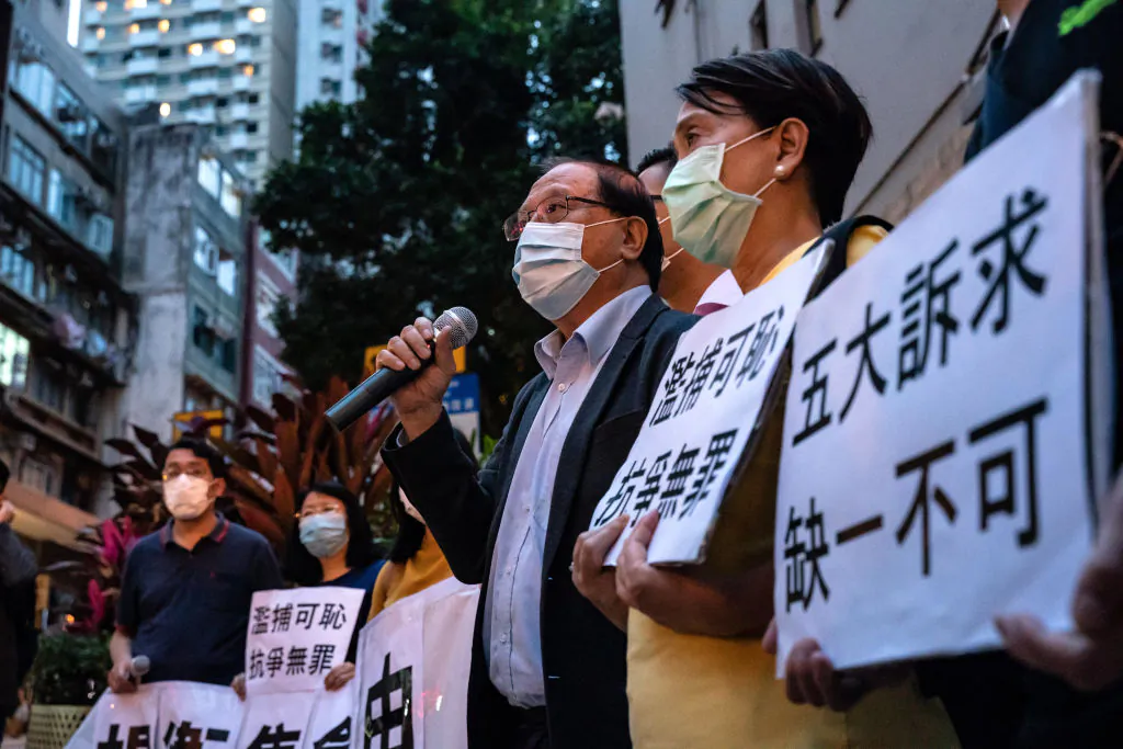 Pro-democracy supporters hold banners and shout slogans outside of the Western District police station in Hong Kong on April 18, 2020,  after at least 14 pro-democracy veterans and supporters were arrested. (Anthony Kwan/Getty Images)