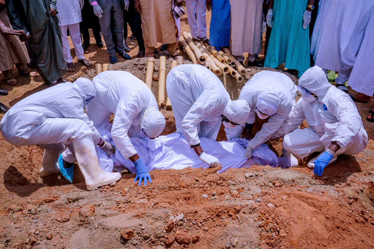 Men wearing protective gear bury the body of Nigerian president's chief of staff, Abba Kyari, who died on Friday after contracting COVID-19, at Gudu Cemetery in Abuja, Nigeria April 18, 2020. (Nigeria Presidency/Handout via Reuters.)