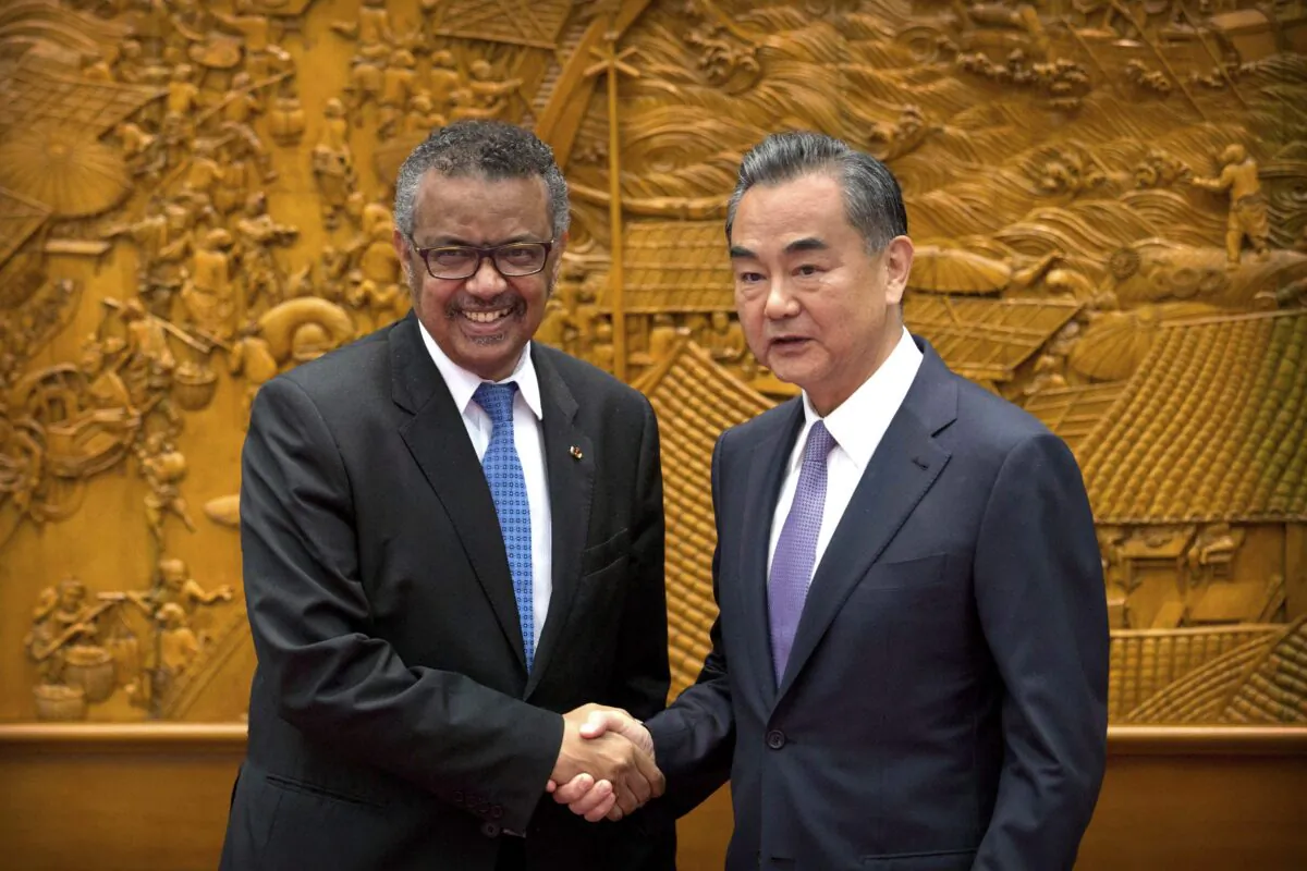 WHO Director-General Tedros Adhanom Ghebreyesus shakes hands with Chinese Foreign Minister Wang Yi as he arrives for a meeting at the Ministry of Foreign Affairs in Beijing, on July 17, 2018. (AP Photo/Mark Schiefelbein, Pool)